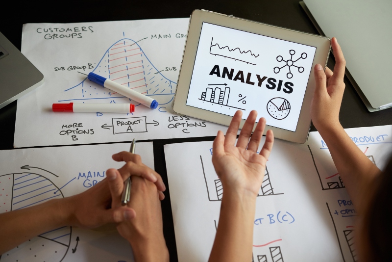 Various charts and graphs on table of business people whe are having meeting Navigating Your Industry with Strategic Competitor Analysis