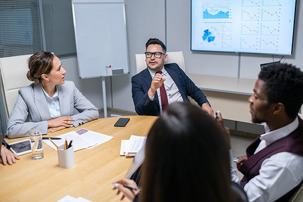 mature-business-coach-talking-to-young-managers-2023-11-27-05-24-40-utc Mature business coach talking to young managers